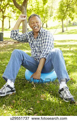 Stock Photo - Senior man sitting on spacehopper. Fotosearch