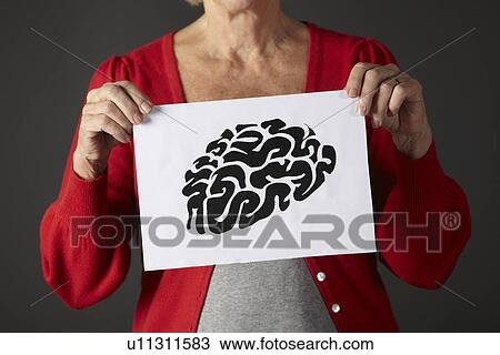 Stock Image - Senior woman holding ink drawing of brain. Fotosearch