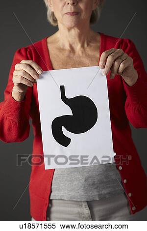 Stock Photography - Senior woman holding ink drawing of stomach. Fotosearch