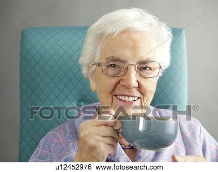 Senior Woman Relaxing In Chair With Hot Drink View Large Photo Image Stock Photograph - Senior Woman Relaxing In Chair With Hot Drink. Fotosearch