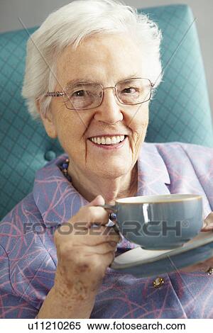 Stock Photography - Senior Woman Relaxing In Chair With Hot Drink. Fotosearch