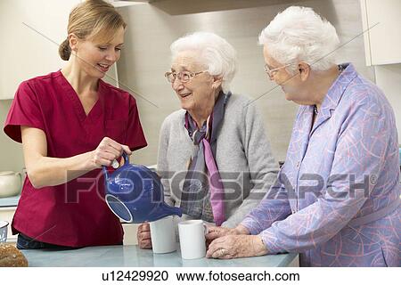 Stock Image - Senior women at home with carer. Fotosearch
