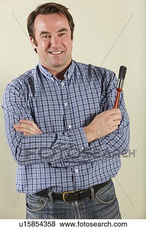 Stock Photo - Studio Shot Of Middle Aged Man Holding Paintbrush. Fotosearch