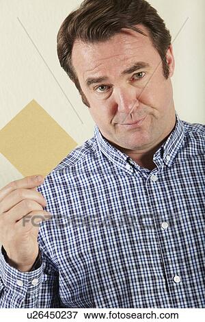 Stock Photo - Studio Shot Of Middle Aged Man Holding Wage Packet. Fotosearch