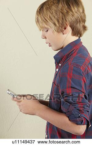 Stock Photo - Studio Shot Of Young Boy Holding Tablet Computer. Fotosearch