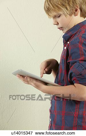 Stock Photo - Studio Shot Of Young Boy Holding Tablet Computer. Fotosearch