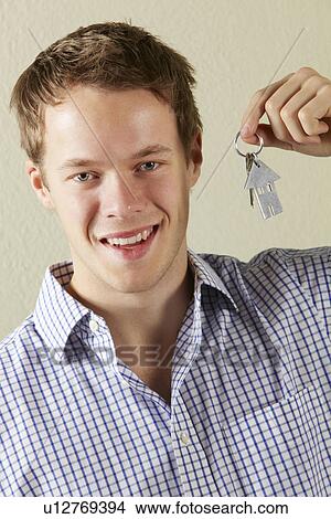 Picture - Studio Shot Of Young Man Holding Keys To First Home. Fotosearch