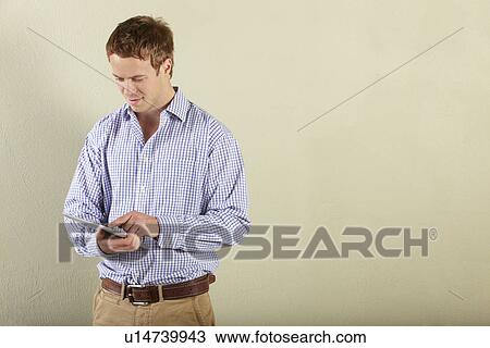 Studio Shot Of Young Man Using Tablet Computer View Large Photo Image Stock Image - Studio Shot Of Young Man Using Tablet Computer. Fotosearch
