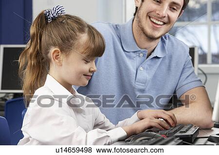 Teacher helping girl using computer in class View Large Photo Image Stock Photo - Teacher helping girl using computer in class. Fotosearch
