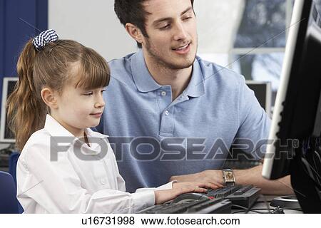 Stock Photo - Teacher helping girl using computer in class. Fotosearch