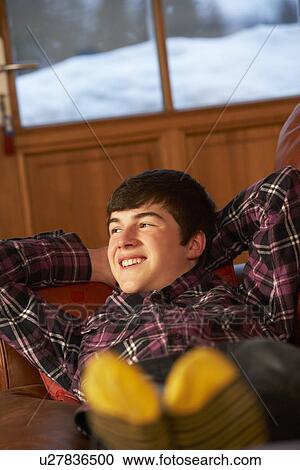 Stock Image - Teenage Boy Relaxing On Sofa. Fotosearch