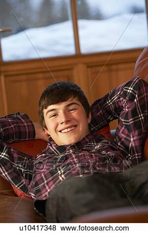 Stock Photo - Teenage Boy Relaxing On Sofa. Fotosearch