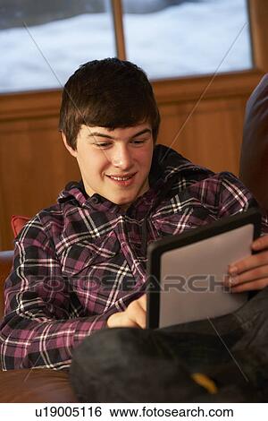 Teenage Boy Relaxing On Sofa With Tablet Computer View Large Photo Image Stock Photograph - Teenage Boy Relaxing On Sofa With Tablet Computer. Fotosearch