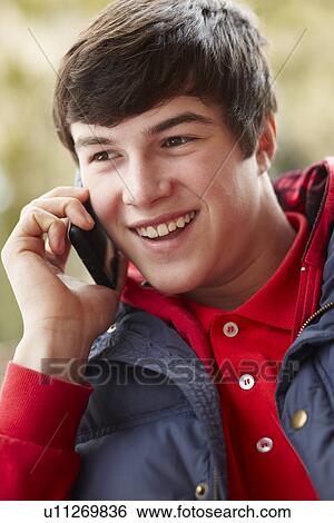 Stock Photograph - Teenage Boy Talking On Smartphone Wearing Winter Clothes. Fotosearch