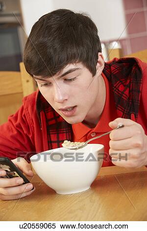 Teenage Boy Teenage Texting Whilst Eating Breakfast View Large Photo Image Stock Photography - Teenage Boy Teenage Texting Whilst Eating Breakfast. Fotosearch