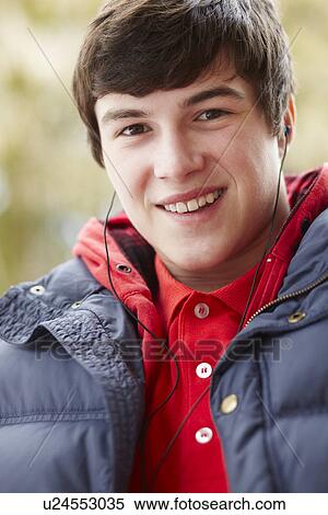 Teenage Boy Wearing Earphones And Listening To Music Wearing Winter Clothes View Large Photo Image Stock Photography - Teenage Boy Wearing Earphones And Listening To Music Wearing Winter Clothes. Fotosearch