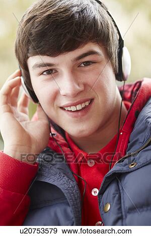 Stock Photo - Teenage Boy Wearing Headphones And Listening To Music Wearing Winter Clothes. Fotosearch