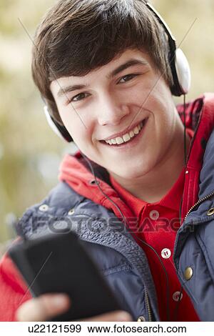 Teenage Boy Wearing Headphones And Listening To Music Wearing Winter Clothes View Large Photo Image Stock Photo - Teenage Boy Wearing Headphones And Listening To Music Wearing Winter Clothes. Fotosearch