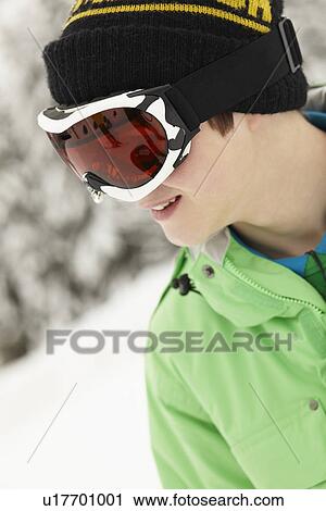 Stock Image - Teenage Boy Wearing Ski Goggles On Ski Holiday In Mountains. Fotosearch