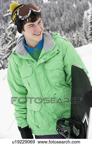 Teenage Boy With Snowboard On Ski Holiday In Mountains View Large Photo Image Stock Photo - Teenage Boy With Snowboard On Ski Holiday In Mountains. Fotosearch