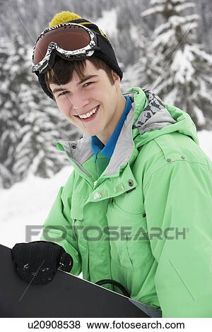 Teenage Boy With Snowboard On Ski Holiday In Mountains View Large Photo Image Stock Photo - Teenage Boy With Snowboard On Ski Holiday In Mountains. Fotosearch