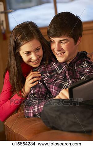 Teenage Couple Relaxing On Sofa With Laptop View Large Photo Image Picture - Teenage Couple Relaxing On Sofa With Laptop. Fotosearch