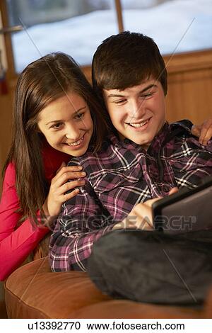 Teenage Couple Relaxing On Sofa With Laptop View Large Photo Image Stock Image - Teenage Couple Relaxing On Sofa With Laptop. Fotosearch