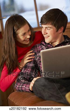 Teenage Couple Relaxing On Sofa With Laptop View Large Photo Image Stock Image - Teenage Couple Relaxing On Sofa With Laptop. Fotosearch