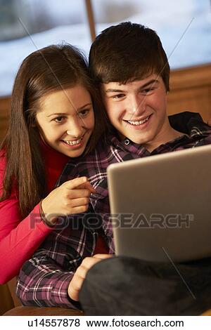 Teenage Couple Relaxing On Sofa With Laptop View Large Photo Image Stock Photo - Teenage Couple Relaxing On Sofa With Laptop. Fotosearch