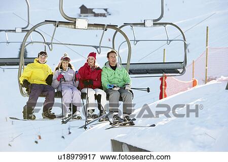 Stock Photo - Teenage Family Getting Off chair Lift On Ski Holiday In Mountains. Fotosearch