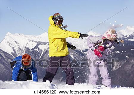 Stock Image - Teenage Family Having Snow Fight In Mountains. Fotosearch
