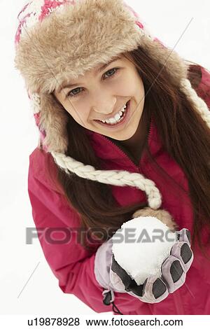 Stock Photo - Teenage Girl Holding Snowball Wearing Fur Hat. Fotosearch