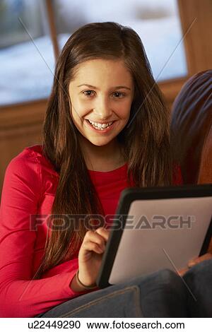 Teenage Girl Relaxing On Sofa With Tablet Computer View Large Photo Image Stock Image - Teenage Girl Relaxing On Sofa With Tablet Computer. Fotosearch