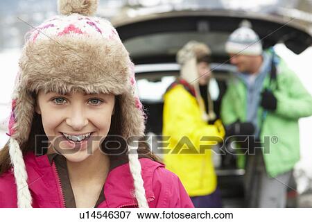 Teenage Girl Smiling At Camera Whilst Family Load Skis In Boot Of Car View Large Photo Image Stock Photo - Teenage Girl Smiling At Camera Whilst Family Load Skis In Boot Of Car. Fotosearch