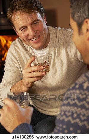 Two Middle Aged Men Relaxing Sitting On Sofa Drinking Whisky View Large Photo Image Stock Photograph - Two Middle Aged Men Relaxing Sitting On Sofa Drinking Whisky. Fotosearch