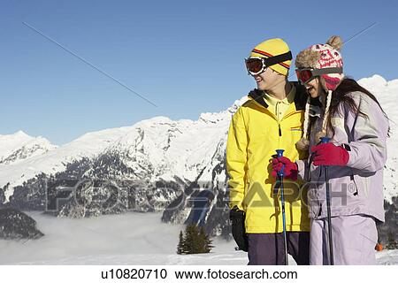 Stock Image - Two Teenagers On Ski Holiday In Mountains. Fotosearch