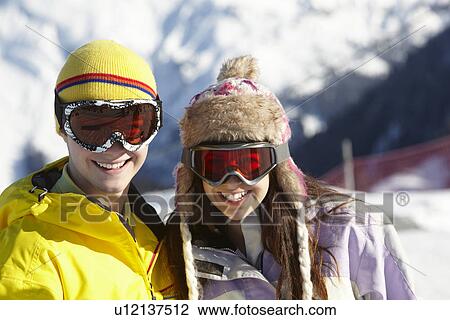 Stock Image - Two Teenagers On Ski Holiday In Mountains. Fotosearch