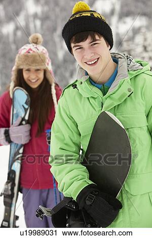 Stock Image - Two Teenagers On Ski Holiday In Mountains. Fotosearch