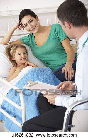 Stock Image - UK Accident and Emergency doctor with mother and child. Fotosearch