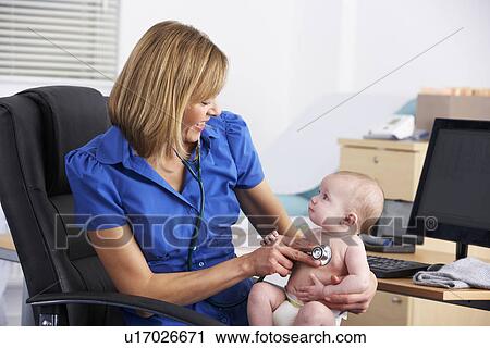 Stock Image - UK doctor examining baby. Fotosearch