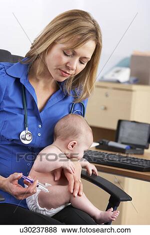 Stock Photo - UK doctor vaccinating baby. Fotosearch