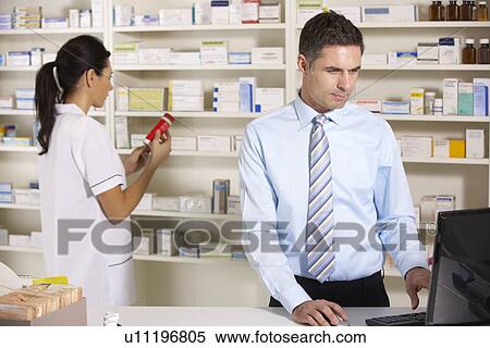 UK nurse and pharmacist working in pharmacy View Large Photo Image Stock Photography - UK nurse and pharmacist working in pharmacy. Fotosearch