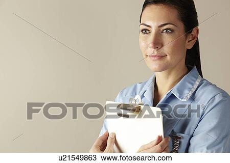 Stock Image - UK nurse holding clipboard. Fotosearch