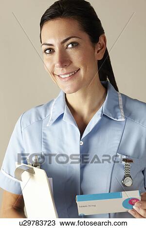 Stock Image - UK nurse holding prescription drug pack. Fotosearch