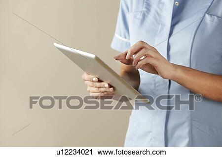 UK nurse using computer tablet View Large Photo Image Stock Image - UK nurse using computer tablet. Fotosearch