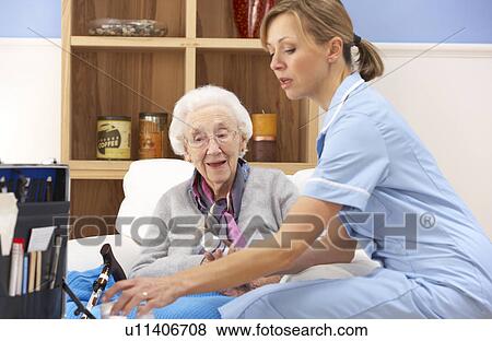 Stock Photo - UK nurse visiting senior woman at home. Fotosearch