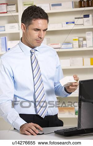 UK pharmacist working on computer View Large Photo Image Stock Photography - UK pharmacist working on computer. Fotosearch