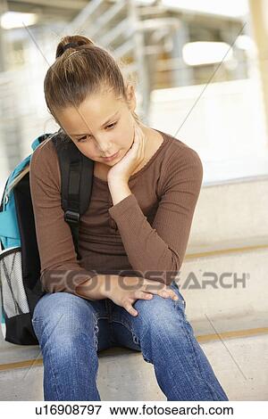 Unhappy Pre teen girl in school View Large Photo Image Stock Photo - Unhappy Pre teen girl in school. Fotosearch