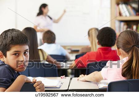 Stock Photo - Unhappy schoolboy in class. Fotosearch