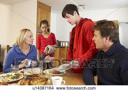 Unhelpful Teenage Clearing Up After Family Meal In Kitchen View Large Photo Image Picture - Unhelpful Teenage Clearing Up After Family Meal In Kitchen. Fotosearch